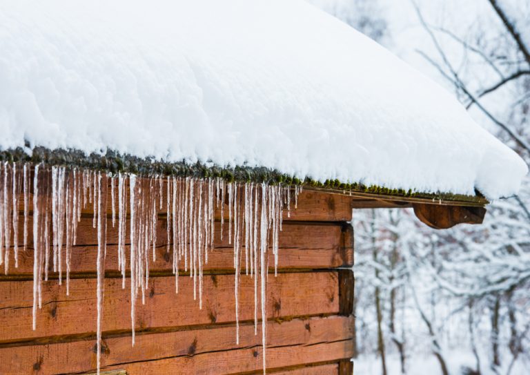 Icicles on gutters, with snowy roof