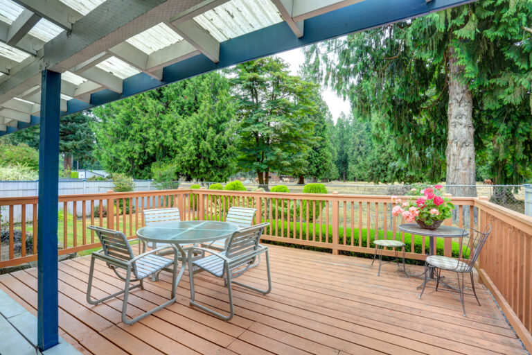 A deck that has chairs and an awning installed